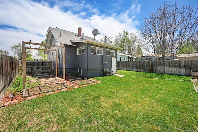 back of house featuring a vegetable garden, a chimney, and a shingled roof