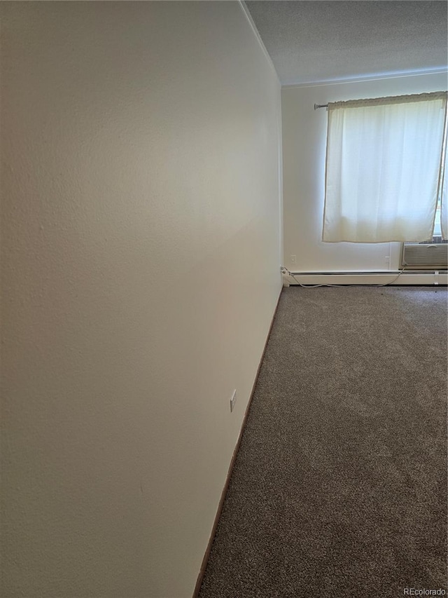 empty room featuring carpet, a textured ceiling, and a baseboard heating unit