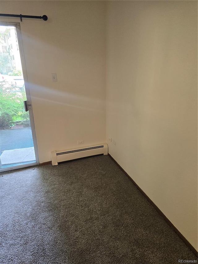 unfurnished room with dark colored carpet and baseboard heating