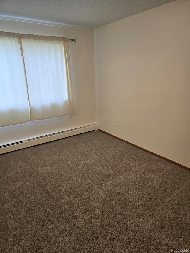 carpeted spare room featuring a baseboard heating unit