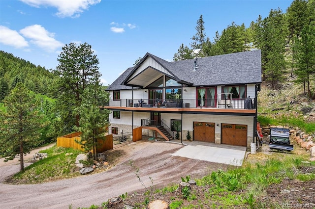663 Brookside Dr, Bailey, CO 80421 - view of front of property featuring driveway, stairs, stone siding, an attached garage, and a wooden deck