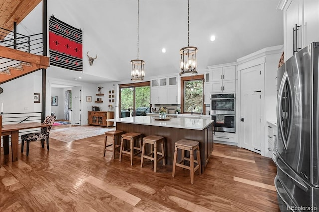 663 Brookside Dr, Bailey, CO 80421 - kitchen featuring appliances with stainless steel finishes, a chandelier, high vaulted ceiling, light countertops, and wood finished floors