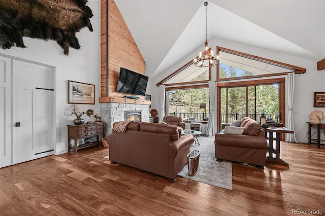 663 Brookside Dr, Bailey, CO 80421 - living area featuring a fireplace, wood finished floors, high vaulted ceiling, and a chandelier