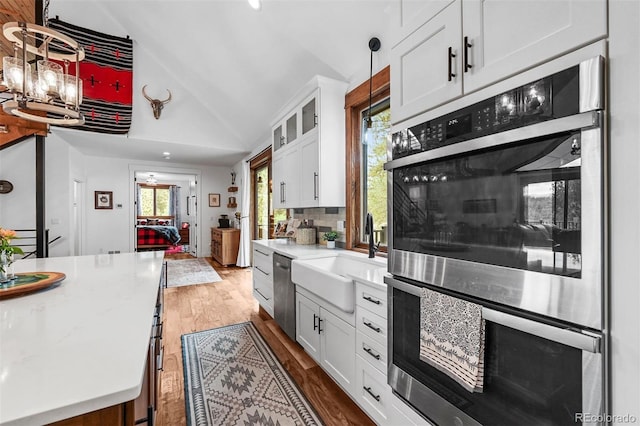 663 Brookside Dr, Bailey, CO 80421 - kitchen with appliances with stainless steel finishes, lofted ceiling, white cabinetry, wood finished floors, and glass insert cabinets