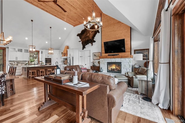 663 Brookside Dr, Bailey, CO 80421 - living area featuring high vaulted ceiling, light wood-style floors, a fireplace, a chandelier, and a ceiling fan