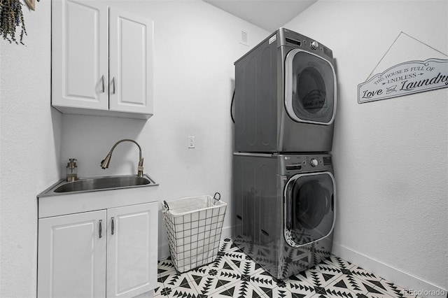 663 Brookside Dr, Bailey, CO 80421 - laundry area featuring stacked washer and clothes dryer, cabinet space, and light tile patterned flooring