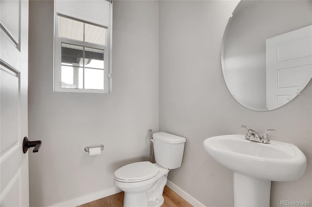 10912 Memphis Ct, Commerce City, CO 80022 - half bathroom with toilet, baseboards, wood finished floors, and a sink