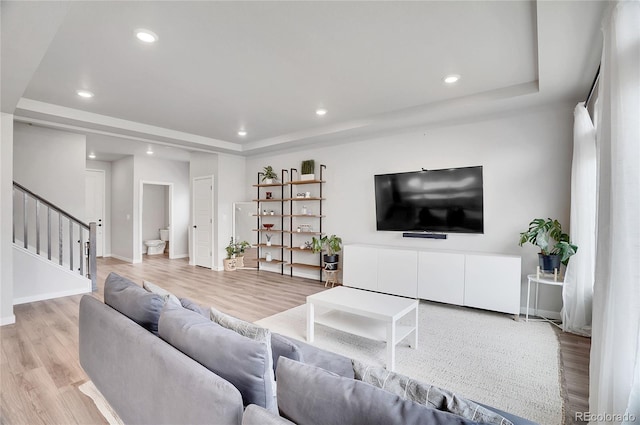 10912 Memphis Ct, Commerce City, CO 80022 - living room with a tray ceiling, stairway, light wood-style floors, baseboards, and recessed lighting