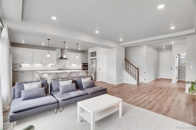 10912 Memphis Ct, Commerce City, CO 80022 - living room with stairs, light wood-style floors, recessed lighting, and baseboards