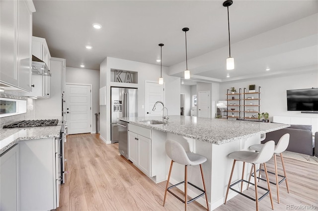 10912 Memphis Ct, Commerce City, CO 80022 - kitchen featuring a sink, light wood finished floors, open floor plan, recessed lighting, and high quality appliances