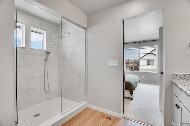 10912 Memphis Ct, Commerce City, CO 80022 - ensuite bathroom with tiled shower, wood finished floors, vanity, and baseboards