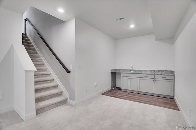 10912 Memphis Ct, Commerce City, CO 80022 - below grade area with baseboards, stairway, carpet flooring, wet bar, and recessed lighting