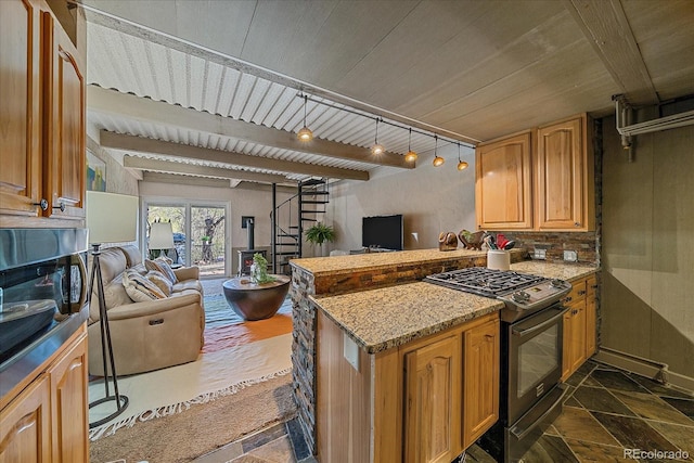 kitchen with a peninsula, open floor plan, stone finish flooring, and black gas stove