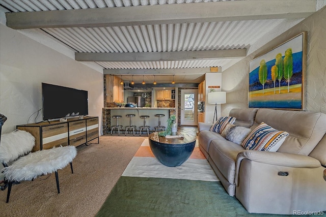 carpeted living area with beamed ceiling