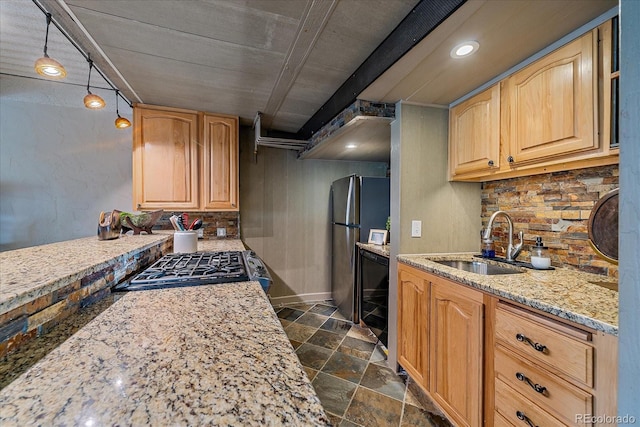 kitchen with stone finish floor, decorative backsplash, a sink, light stone counters, and freestanding refrigerator