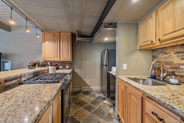 kitchen with decorative backsplash, appliances with stainless steel finishes, light stone countertops, a sink, and stone tile floors