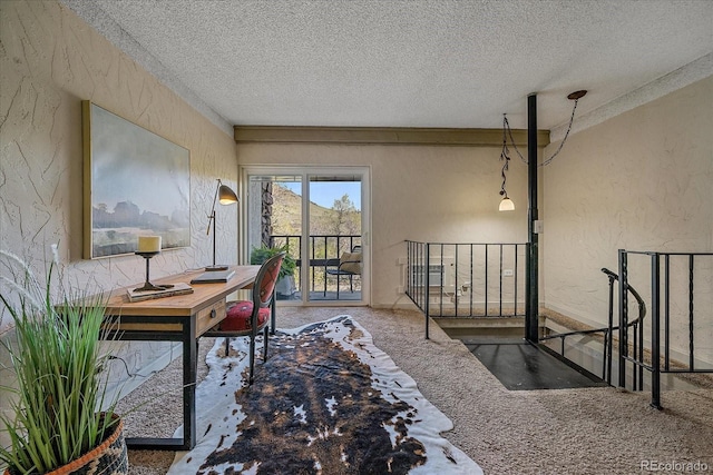 office featuring carpet floors, a textured wall, and a textured ceiling