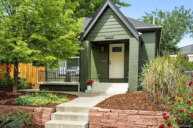 1331 Osceola St, Denver, CO 80204 - bungalow-style house featuring a porch, brick siding, and roof with shingles
