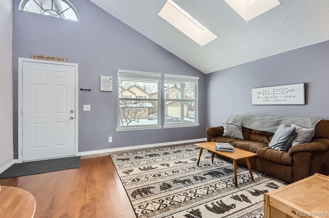 living room featuring dark hardwood / wood-style floors, a skylight, and high vaulted ceiling