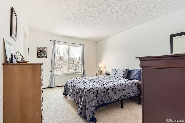 bedroom featuring light colored carpet and a textured ceiling