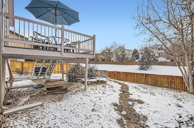 yard layered in snow with a deck