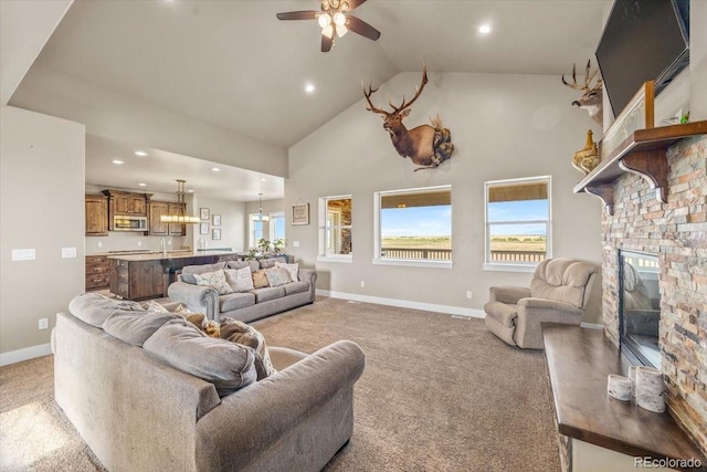 45425 Wolf Creek Dr, Bennett, CO 80102 - living area with light carpet, a ceiling fan, high vaulted ceiling, recessed lighting, and a stone fireplace