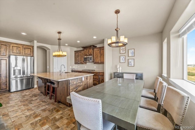 45425 Wolf Creek Dr, Bennett, CO 80102 - dining room with a chandelier, arched walkways, recessed lighting, and dark stone finish floors