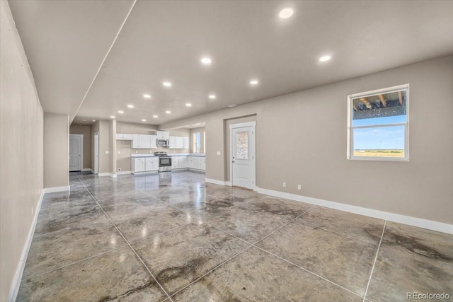 45425 Wolf Creek Dr, Bennett, CO 80102 - unfurnished living room with recessed lighting and plenty of natural light