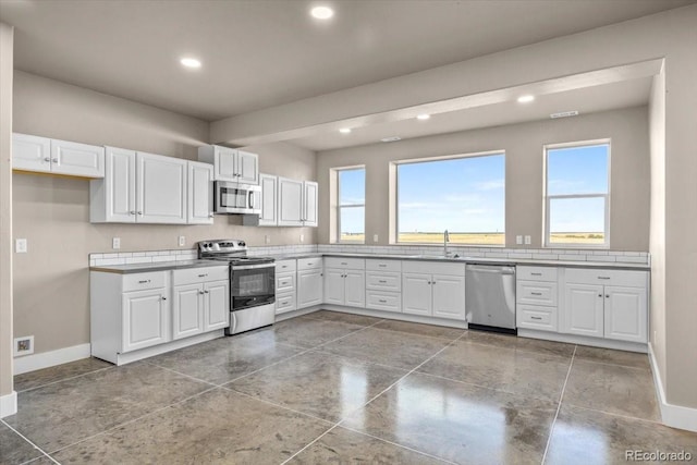 45425 Wolf Creek Dr, Bennett, CO 80102 - kitchen with stainless steel appliances, white cabinets, and recessed lighting
