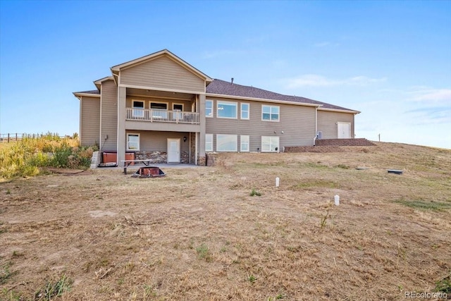 45425 Wolf Creek Dr, Bennett, CO 80102 - back of house featuring an outdoor fire pit and a balcony