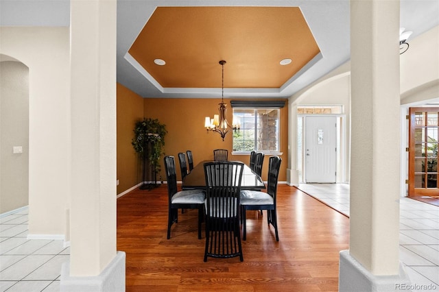 6427 S Tibet St, Aurora, CO 80016 - dining area featuring arched walkways, wood finished floors, plenty of natural light, and a chandelier