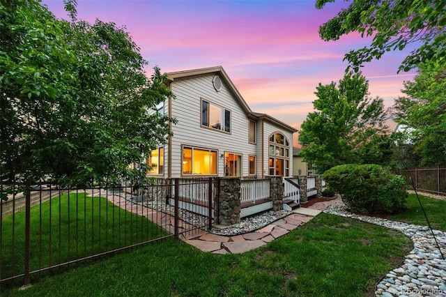 6427 S Tibet St, Aurora, CO 80016 - back of house at dusk with a wooden deck and stone siding