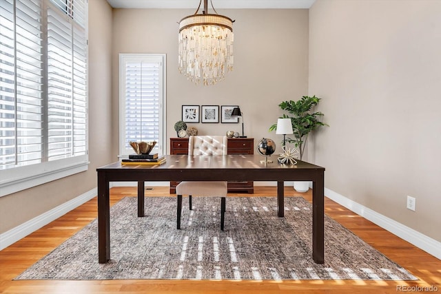 home office with wood finished floors, baseboards, and a notable chandelier