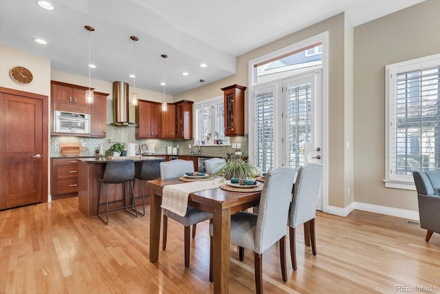 dining area with baseboards, light wood-style flooring, recessed lighting, and plenty of natural light