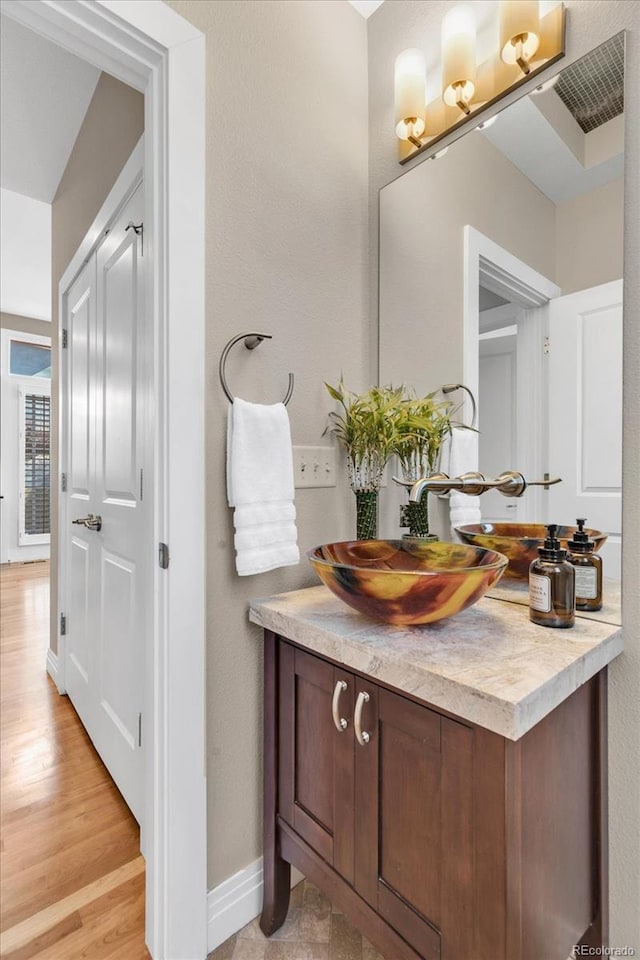 bathroom with vanity, baseboards, and wood finished floors