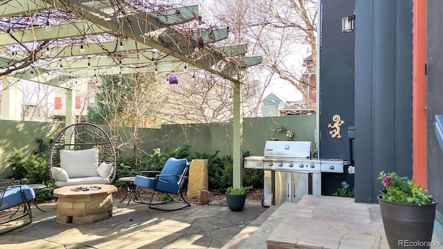 view of patio with a fenced backyard, an outdoor fire pit, and area for grilling