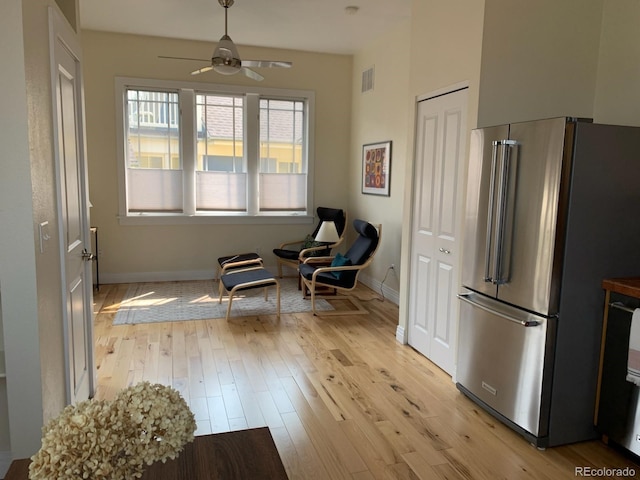 sitting room featuring baseboards, ceiling fan, light wood-style flooring, and visible vents