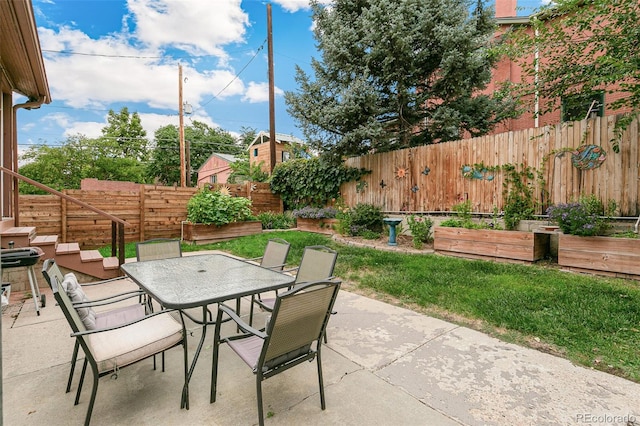 view of patio with a garden, outdoor dining area, and fence