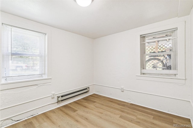 spare room with light wood-type flooring and a baseboard radiator