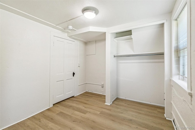 unfurnished bedroom featuring light wood-style floors and a closet