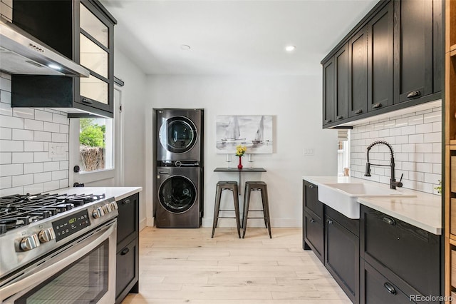 3625 W 9th Ave, Denver, CO 80204 - kitchen with gas stove, stacked washer / drying machine, a sink, decorative backsplash, and recessed lighting