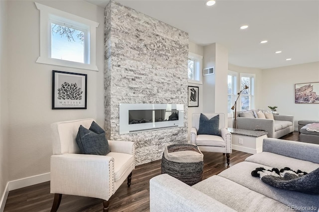 living area with dark wood finished floors, visible vents, and baseboards