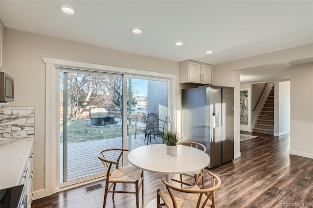 dining area with recessed lighting, visible vents, dark wood-type flooring, and stairs