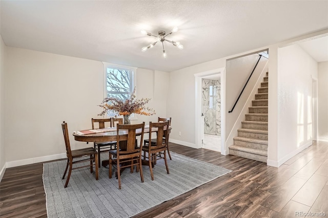 dining area featuring dark wood-type flooring, baseboards, a chandelier, stairs, and a textured ceiling