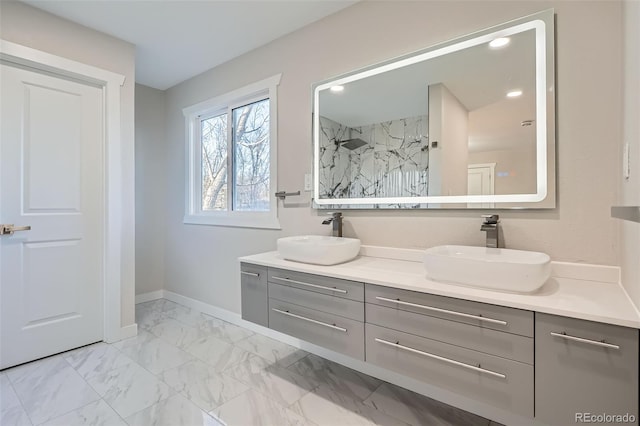 bathroom with a sink, marble finish floor, walk in shower, and double vanity