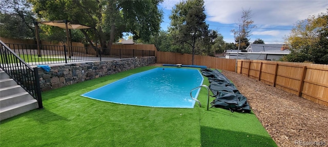 view of pool featuring a fenced in pool, a lawn, a fenced backyard, and a diving board