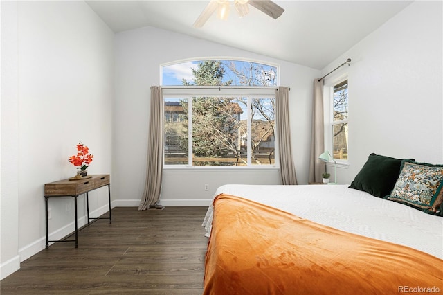 bedroom featuring ceiling fan, dark hardwood / wood-style flooring, multiple windows, and vaulted ceiling