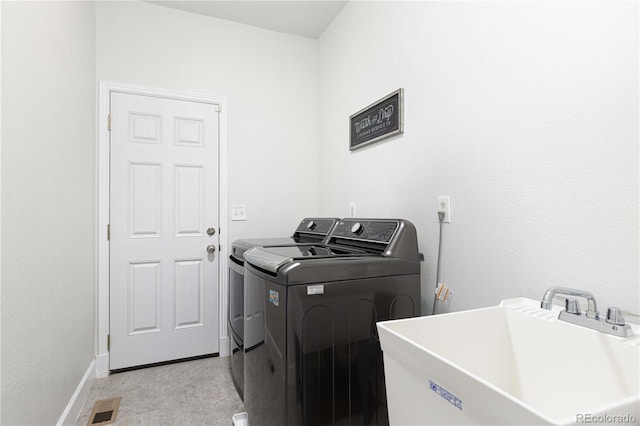 washroom with washer and clothes dryer and sink