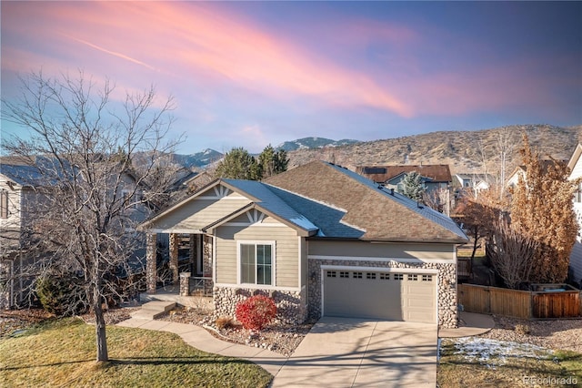 craftsman-style house with a lawn, a mountain view, and a garage