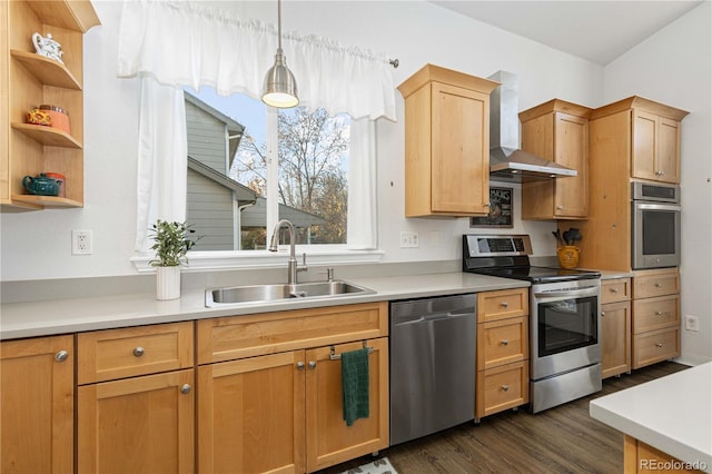 kitchen featuring sink, wall chimney exhaust hood, dark wood-type flooring, decorative light fixtures, and appliances with stainless steel finishes